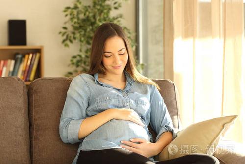 自豪的怀孕女人看她的肚子