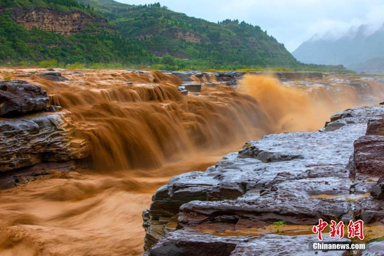雨中黄河壶口瀑布更显壮观 游客拍照留念