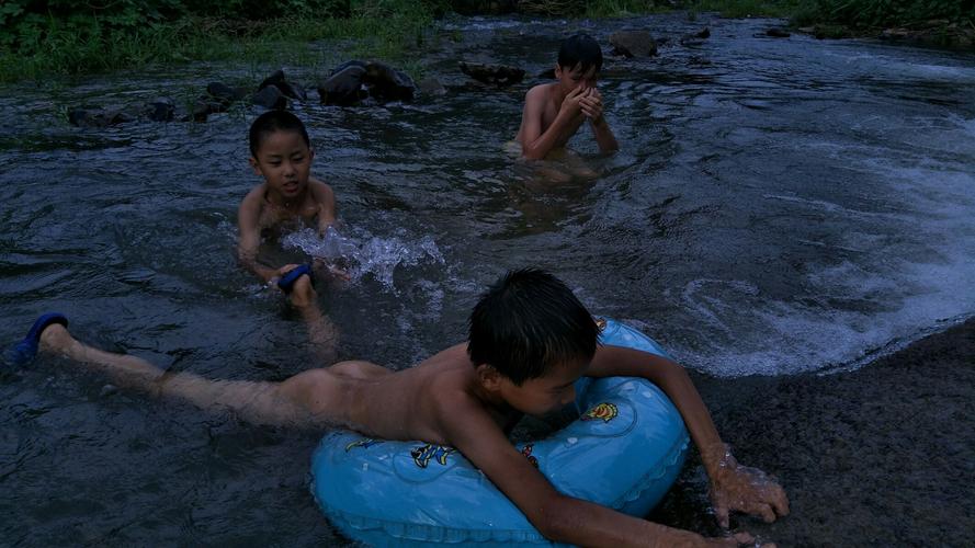 炎炎夏日,孩子们在小河里戏水