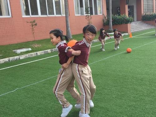 我校小学部三年级成功举行背对背夹球接力比赛