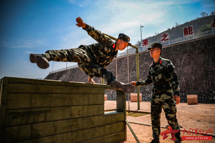 400米障碍训练中,官兵快速飞跃矮墙