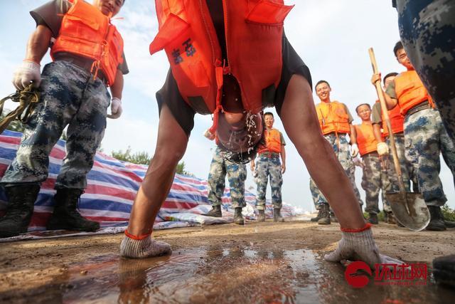 江西九江:抗洪战士加固圩堤上水后,被倒控灌进防水裤