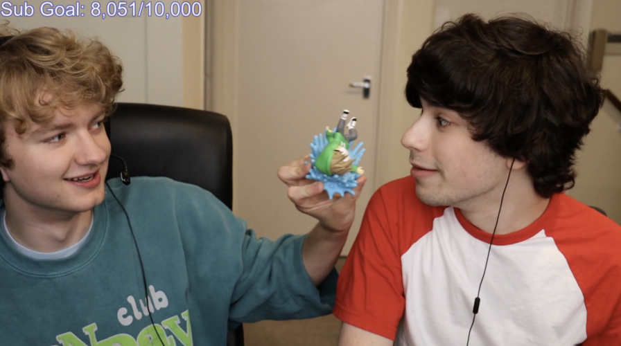 热爱整活的小孩直接拿着dream的手办就往george嘴唇上凑.