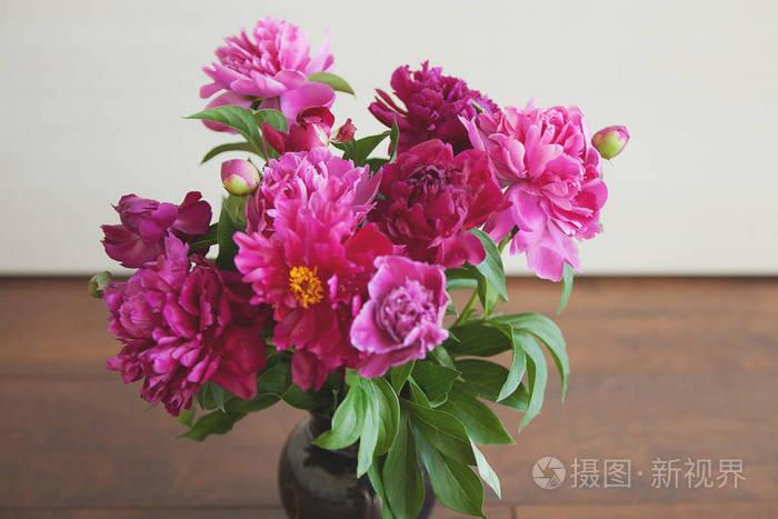 一束美丽的牡丹花在花瓶里, 矗立在木地板上
