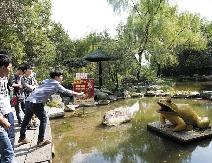 金蟾许愿池,一男生正在投币许愿.