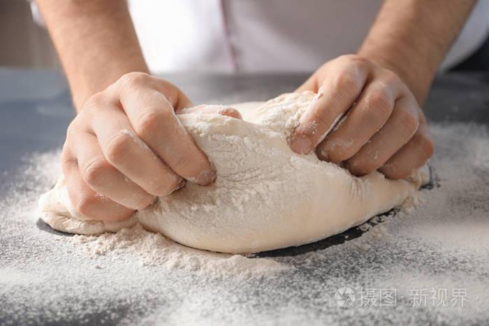 用面粉洒在桌上的人捏面团