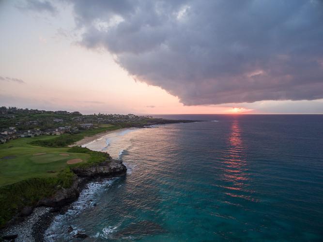 the sun sets over the ocean and kapuala cliffs.