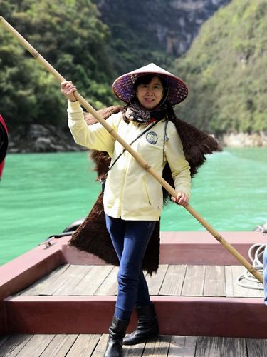 穿蓑衣,带斗笠,竹竿撑船留念.