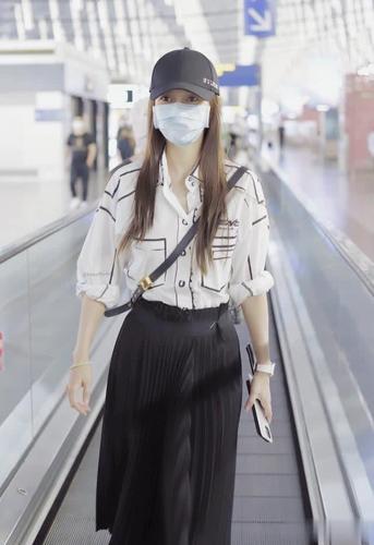 angelababy机场时装秀,白色衬衫搭配百褶裙,手拿菜刀手机想干嘛