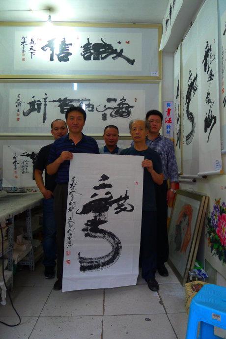 书画家胡俊峰在北京前门大手笔画室为董新有书写对联龙腾海浪高,马啸