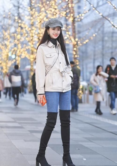 美女白色的风衣,搭配牛仔裤过膝靴,时尚又靓丽!