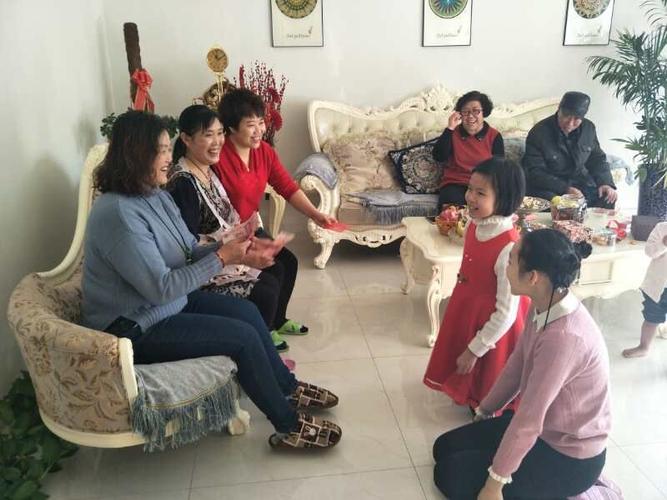瞧,家人们坐在沙发上,小孩们给长辈们拜年要压岁钱呢.