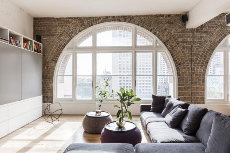 拱形落地窗户搭配白色的框架,原始粗糙质感的红砖,在阳光的映衬下