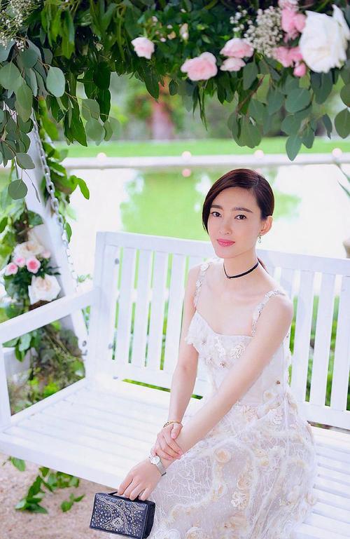 王丽坤身穿白色低吊带裙,裙身上点缀淡黄色的小花,彰显出她优雅和知性