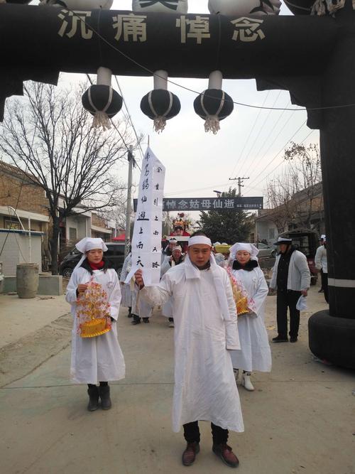 外孙手持引路幡,外孙女手持""金元宝""等在丧车前边,为老人开路送行!