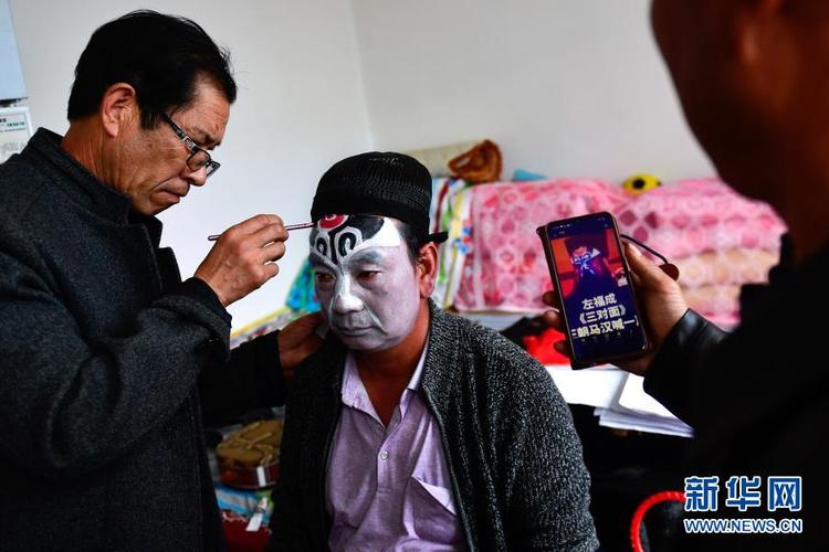2月21日,山庄村秦腔业余剧团团长陈玉成(中)在演出前化妆.