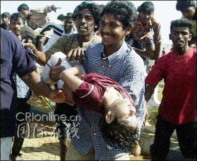一位印度人怀抱一个小女孩的尸体
