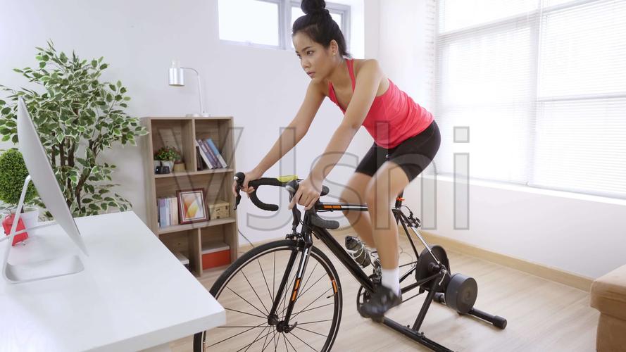 自行车手她在家里锻炼.