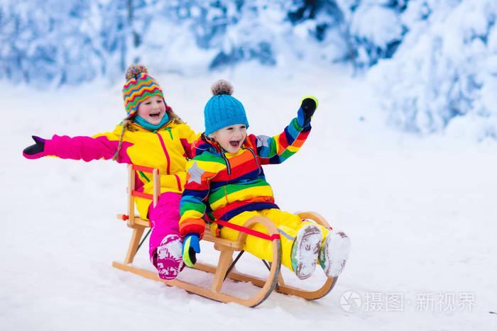 孩子们在雪地里玩.儿童冬季驾雪橇