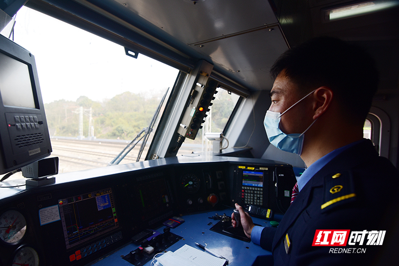 张文民在和谐号电力机车驾驶室内操纵机车.