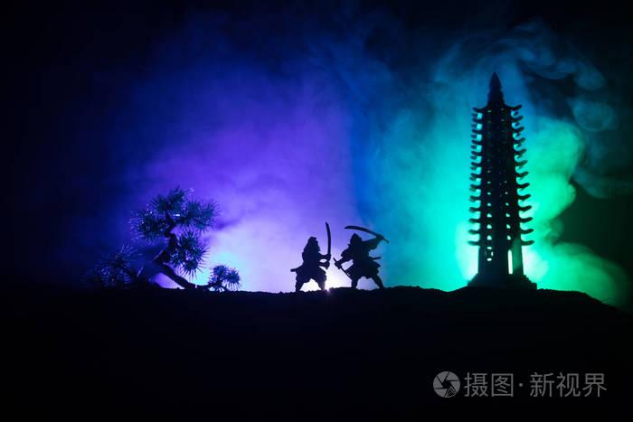 武士的剪影在树和老寺庙附近决斗.表装饰与深色色调的雾背景.