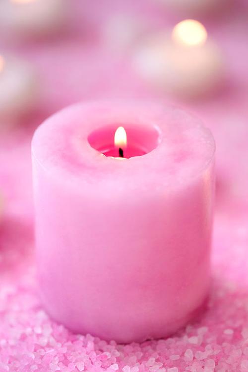 放在桌子上的粉色浴盐和蜡烛