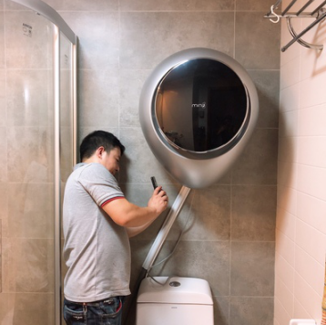 一名师傅正帮助消费者安装壁挂式洗衣机