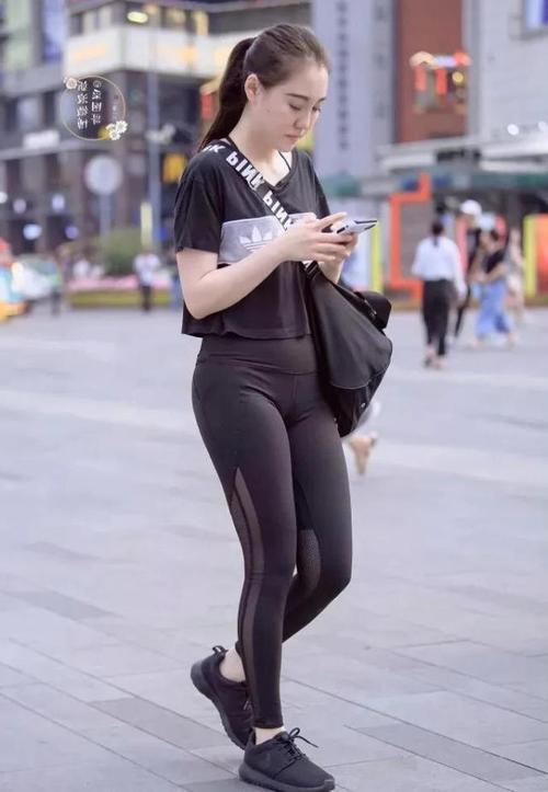 紧身裤小辣妹显凹凸线条低头玩手机成了一道时尚风景线