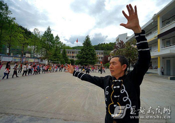 4月23日,在恩施市三岔镇中心小学,傩戏传承人张永明正在教学生跳傩舞.