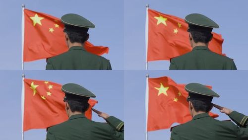 4k军人穿向飘动的五星红旗敬礼实拍素材