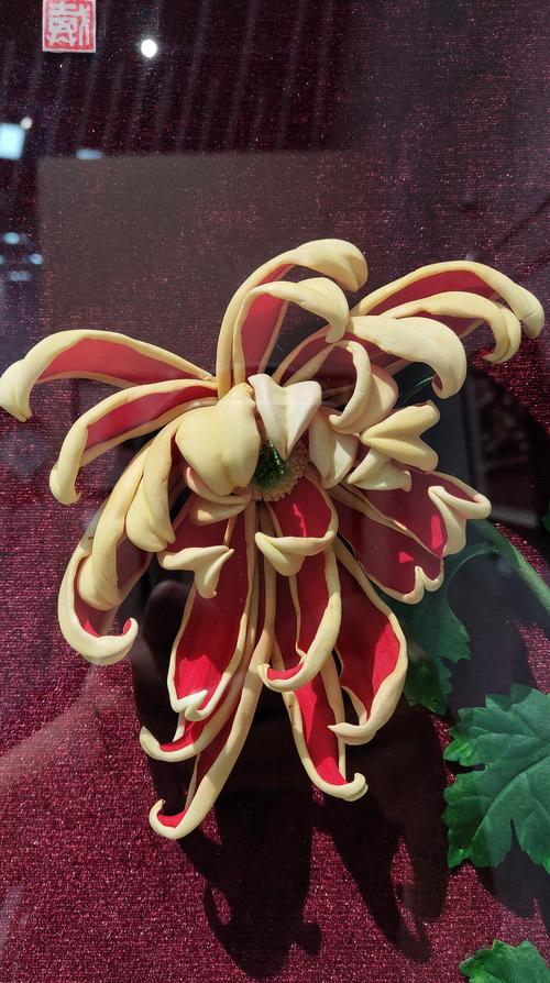 上图是一盆石榴花,是由年近八十的通草花大师钱宏仁制作,从枝干到花朵