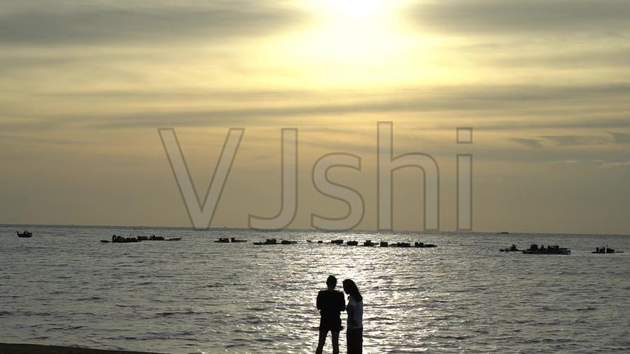 夕阳下海边的情侣剪影