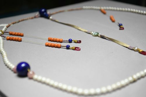 此盘朝珠按清代定式制造,共由108颗珍珠组成,另有青金石佛头四颗.