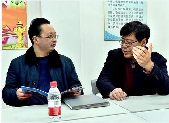郑世东(左)与谭兵(右)深入探讨共同打造全国民族文化示范社区的工作