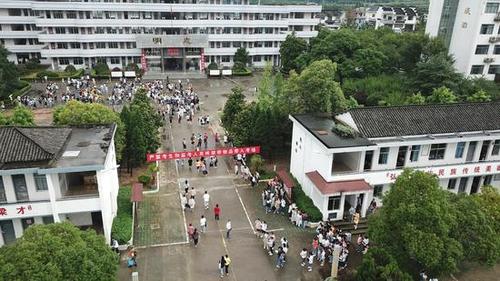 上午8时10分许,歙县二中考点,老师向考生发放口罩.