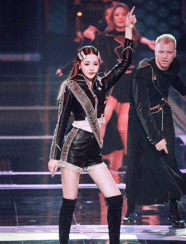 迪丽热巴参加跨年盛典时的镜头,穿着黑色皮衣装的她站在一群欧美伴舞