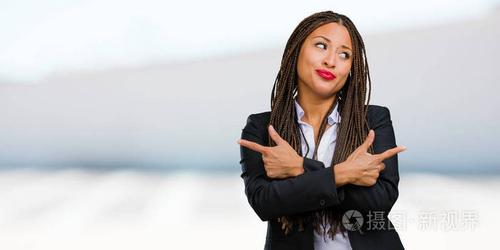 一个年轻的黑人企业妇女的肖像困惑和可疑的人, 决定在两个选项, 犹豫