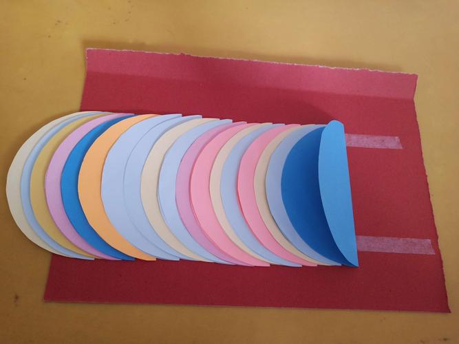 把之前剪下的18张半圆形以此类推放到红色卡纸上,摁牢固.