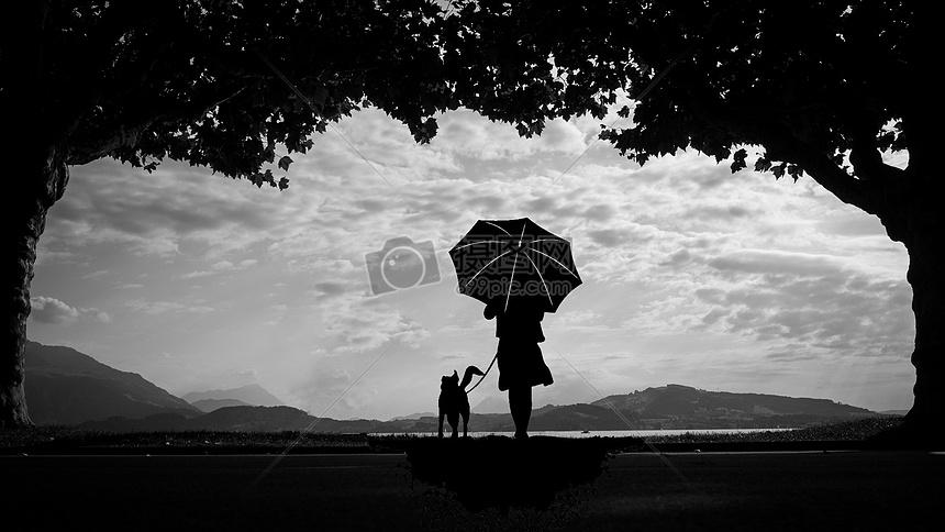女人与狗等候的背影剪影