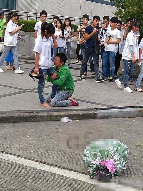男孩下跪抱女孩大腿求爱 女孩将花扔到一边表情痛苦