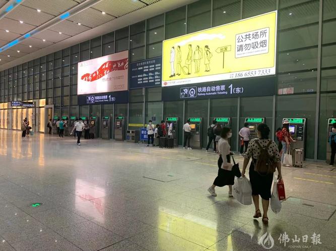 在佛山西站内,部分旅客正在通过进站闸口旁的自助售票机购票进站.