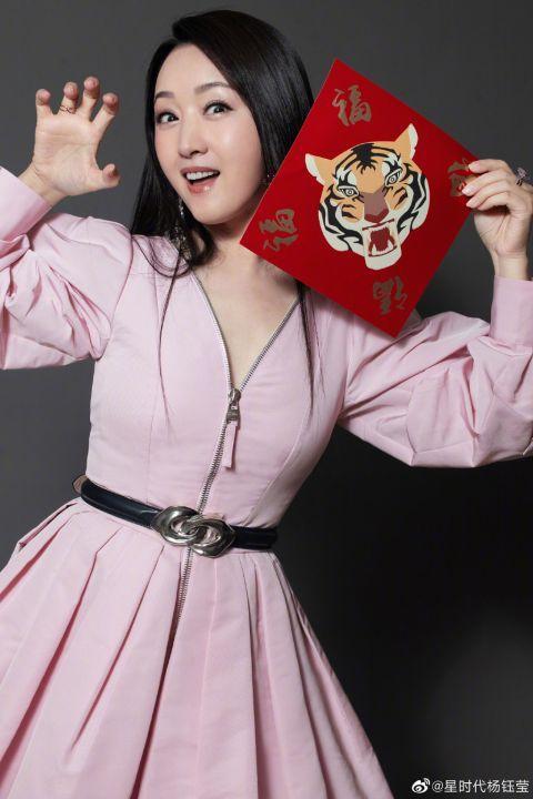 杨钰莹穿粉红束腰裙拍虎年写真手举福字灵动俏皮