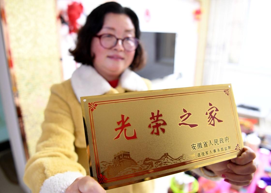 1月14日,合肥市包河区常青街道居民魏松梅在展示领到的"光荣之家"牌.