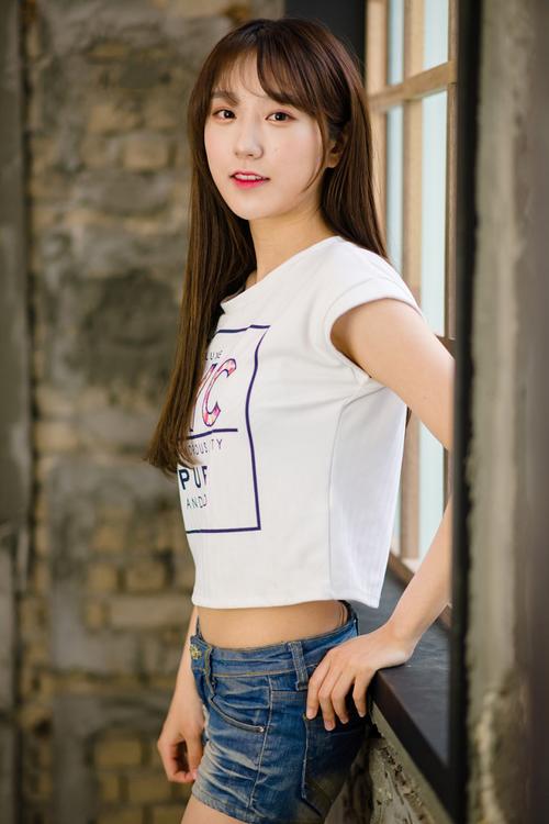 一个穿牛仔短裤和白色t恤的清秀姑娘