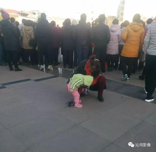好,然后在围观群众背后却发生不雅一幕,一位长辈带着孩子在广场上小便