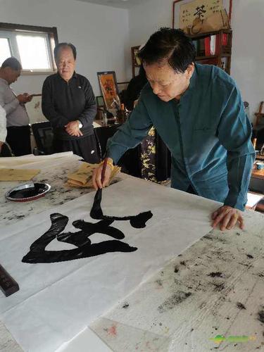 青岛"通胜源"董事长魏鸿山请著名书法家王奎鑫挥毫泼墨