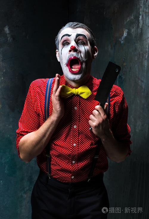 恐怖的小丑手持一把刀上繁星万圣节的概念