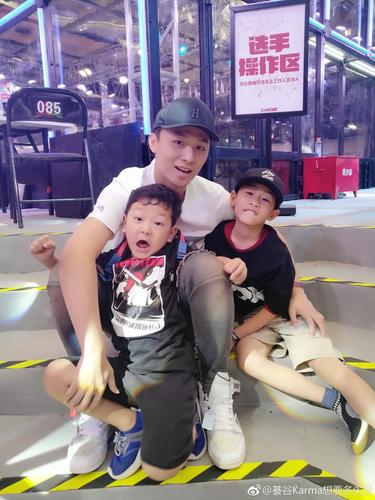 照片中的张恒五官帅气不输小鲜肉,头戴黑色帽子,抱着两个小孩子超级有