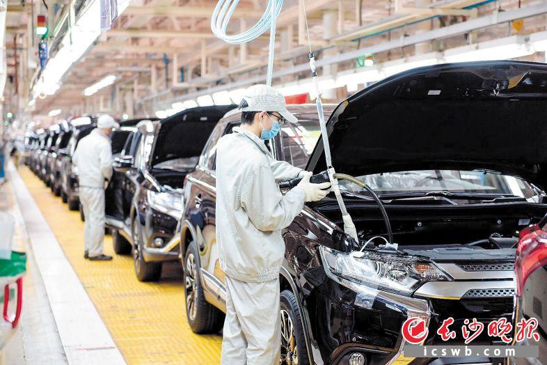 广汽三菱长沙工厂总装车间,产业工人们正在组装汽车.
