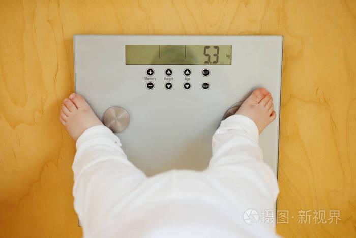 婴儿站在电子秤上显示其重量